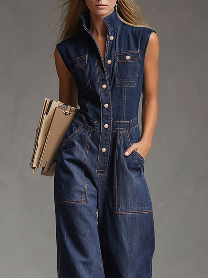 Dark blue denim FJØRNA women's sleeveless balloon jumpsuit with multi-pocket design, featuring a relaxed fit and stylish silhouette.