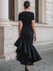 Black FJØRNA asymmetric ruffle-hem midi dress featuring a stylish ruffle detail and elegant silhouette.