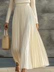 Cream satin pleated maxi dress by FJØRNA featuring a flowing silhouette and elegant pleats, perfect for casual occasions.