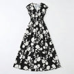 Women's floral print V-neck summer maxi dress by FJØRNA, flowing fabric with vibrant floral pattern and sleeveless design.