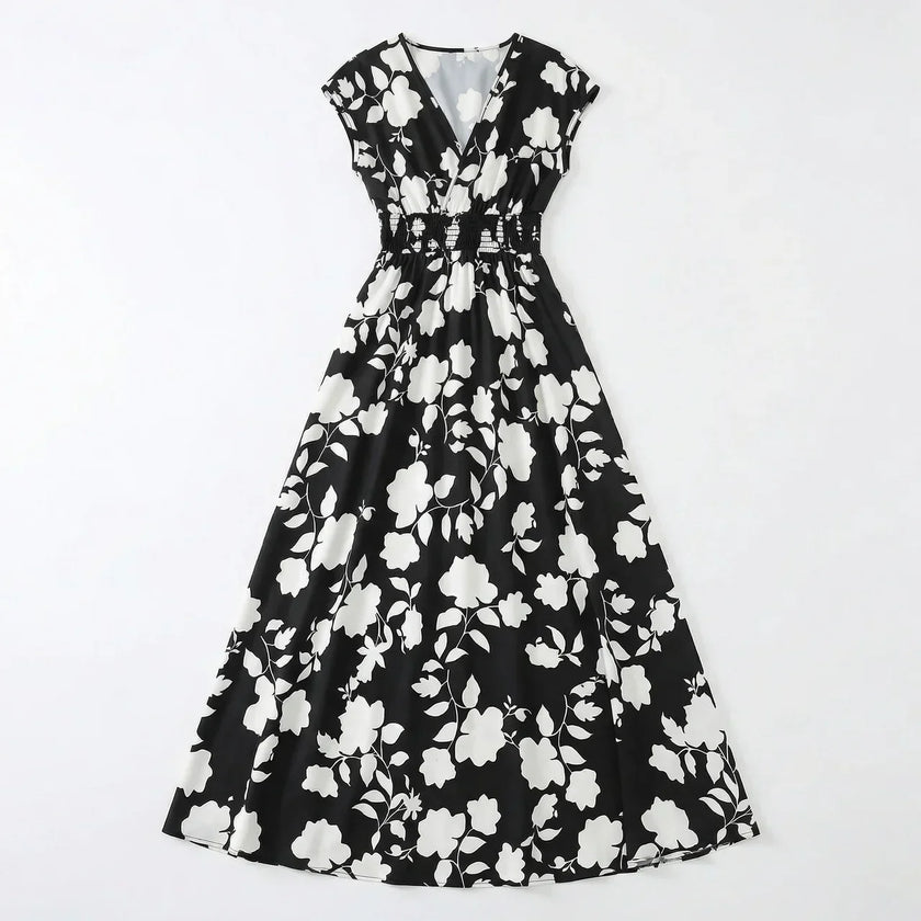 Women's floral print V-neck summer maxi dress by FJØRNA, flowing fabric with vibrant floral pattern and sleeveless design.