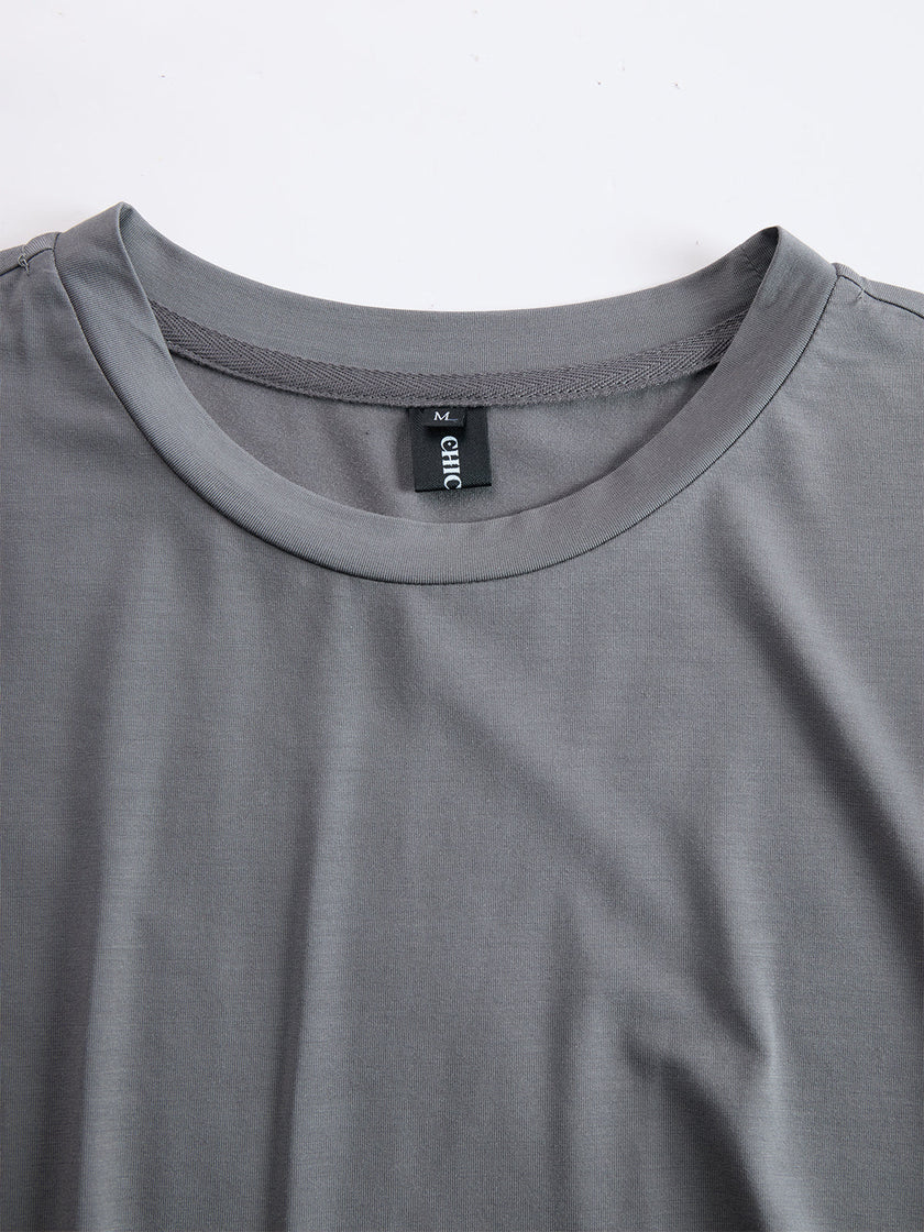 Grey FJØRNA ruched maxi dress for women, featuring a flowing silhouette and elegant design, shown on a model.