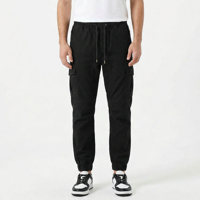 Men's slim fit cotton cargo trousers by FJØRNA, shown in a neutral color, with multiple pockets and a tapered leg fit.