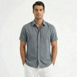 Men's FJØRNA cotton-linen short sleeve shirt displayed on a hanger, featuring a casual design with a button-up front and collar.