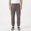 Men's slim fit cotton cargo trousers by FJØRNA, featuring multiple cargo pockets and a tailored fit in a neutral color.