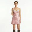 FJØRNA women's satin lace slip mini dress featuring delicate lace details and a smooth satin fabric on a model.