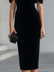 FJØRNA black velvet bow midi dress featuring a fitted silhouette and elegant tie detail at the waist.
