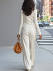 White FJØRNA women's stand collar zip-up wide-leg trouser suit, featuring tailored trousers with a sleek collar and zipper details.