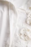 White sleeveless floral embroidery blouse for women by FJØRNA, featuring delicate floral patterns and a stylish sleeveless design.