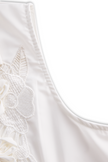 White sleeveless floral embroidery blouse for women by FJØRNA, featuring delicate floral patterns and a lightweight, breathable fabric.