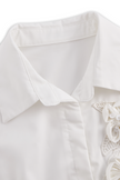White sleeveless floral embroidery blouse for women by FJØRNA, featuring intricate embroidery and a lightweight, feminine design.