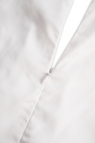 FJØRNA women's white sleeveless floral embroidery blouse, showcasing intricate floral patterns and a sleeveless design.