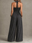 Charcoal pinstripe halter neck wide-leg jumpsuit for women by FJØRNA, shown on a model with a fitted waist and flowing legs.