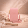 FJØRNA touchscreen crossbody phone bag for women with transparent front, compact design, and adjustable strap.