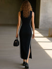 Black knit V-neck maxi dress for women by FJØRNA, featuring a flowing silhouette and long sleeves in a close-up view.