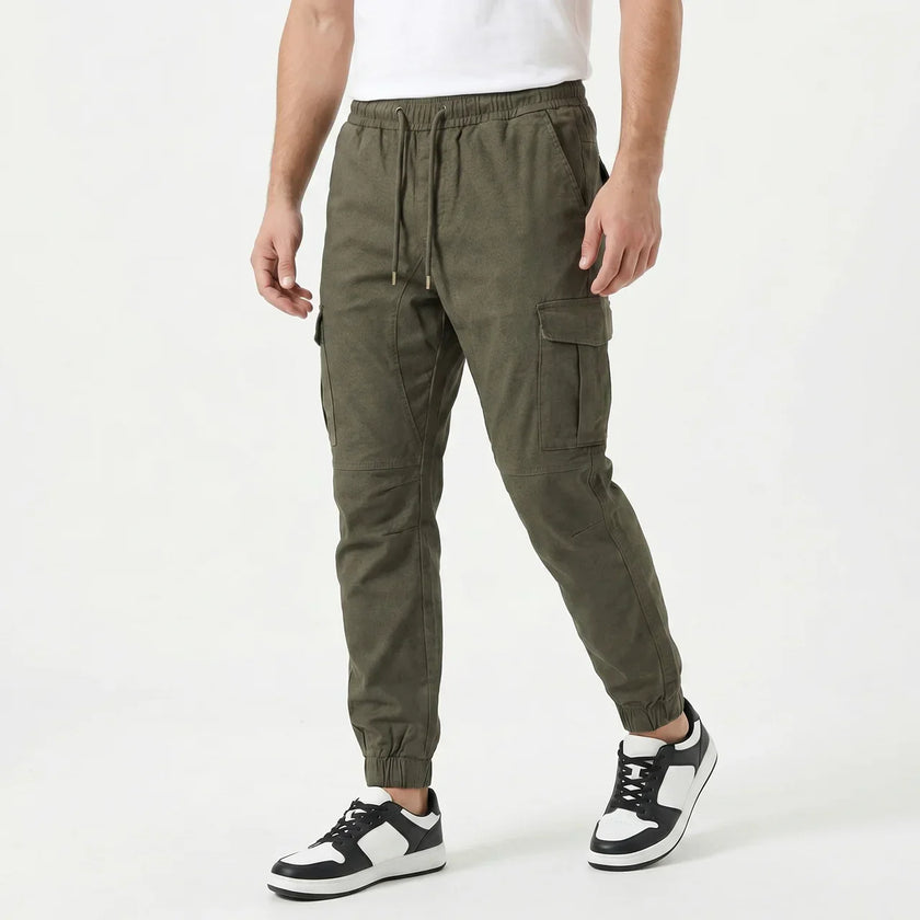 Men's slim fit cotton cargo trousers by FJØRNA, shown in a neutral color with multiple pockets and a modern tapered design.
