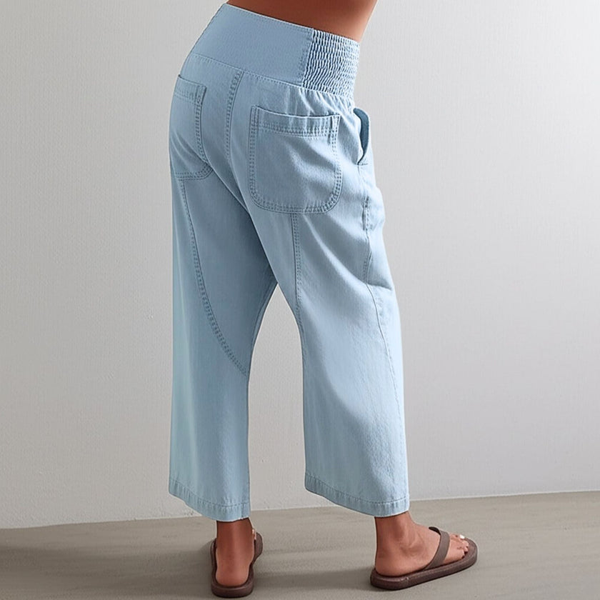 FJØRNA women's wide leg denim trousers featuring a classic blue wash and relaxed fit, styled with pockets and belt loops.