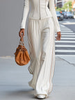 White stand collar zip-up wide-leg women's trouser suit by FJØRNA, featuring tailored pants with a sleek, modern design.