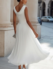 FJØRNA chiffon midi dress for women with draped neckline and pleated design, showcasing a flowing, elegant style.