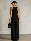 FJØRNA black colour-block V-neck sleeveless jumpsuit with button-down front, designed as stylish women's pants.