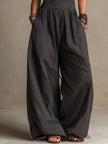 FJØRNA charcoal pinstripe halter neck wide-leg jumpsuit for women, front view showing stylish halter neckline and relaxed wide-leg fit.