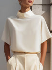 White high-neck minimalist blouse by FJØRNA, featuring draped design and long sleeves, suitable for stylish women's tops.