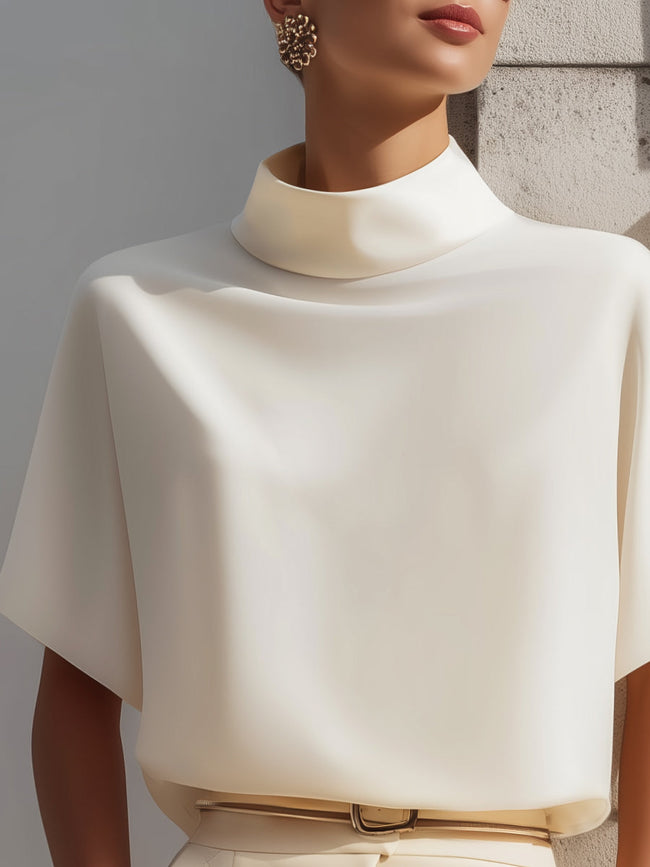 White high-neck minimalist blouse for women by FJØRNA, featuring draped design and elegant long sleeves.