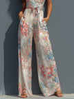 White floral satin halter neck jumpsuit with wide-leg pants, featuring wrap front design by FJØRNA for women.