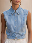 Light wash sleeveless denim vest by FJØRNA, women's button-down top with a casual sleeveless design and classic denim style.