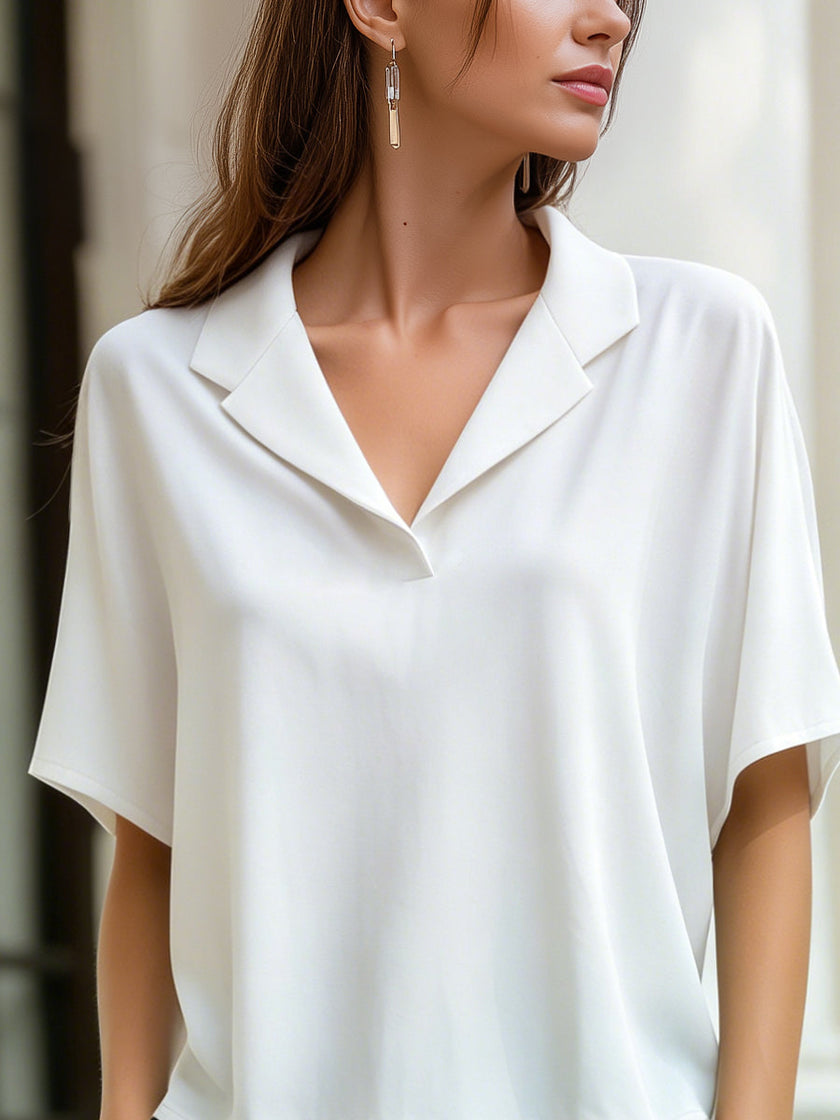 White FJØRNA women's short-sleeve blouse with lapel collar, relaxed fit, and clean, stylish design.