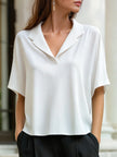 FJØRNA white short-sleeve blouse with lapel collar, relaxed fit, and button-front design, perfect for women's tops.