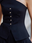 Navy blue FJØRNA women's peplum top with one shoulder design, button details, and structured fit.