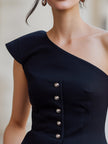 Navy blue FJØRNA women's one-shoulder peplum top with button details and structured design, perfect for stylish occasions.
