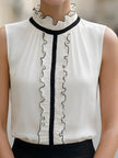 Ivory sleeveless ruffle high-neck blouse for women by FJØRNA, featuring a stylish white top with ruffle details and a high neckline.