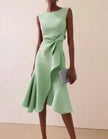 Pink FJØRNA midi dress for women with round neckline, ruffle and bow details, sleeveless design, perfect for summer wear.