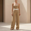 FJØRNA women's pinstripe strapless wide-leg jumpsuit featuring a fitted bodice and flowing pant legs, perfect for wedding guest attire.
