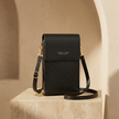 FJØRNA touchscreen crossbody bag for women with a phone compartment, stylish black bag with adjustable strap and sleek design.