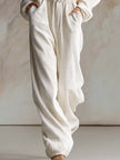 White corduroy hooded jumpsuit with zip front and long sleeves, women's pants by FJØRNA, shown on a model.