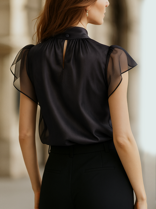 FJØRNA black chiffon high-neck sleeveless blouse for women, elegant top with a flowing chiffon fabric and high neckline.