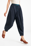 FJØRNA women's linen tapered trousers displayed flat, showcasing light, breathable fabric and modern, elegant design.