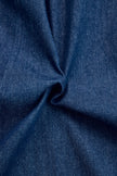 Dark blue FJØRNA denim jumpsuit with wide-leg pants and long sleeves, featuring topstitch detailing.