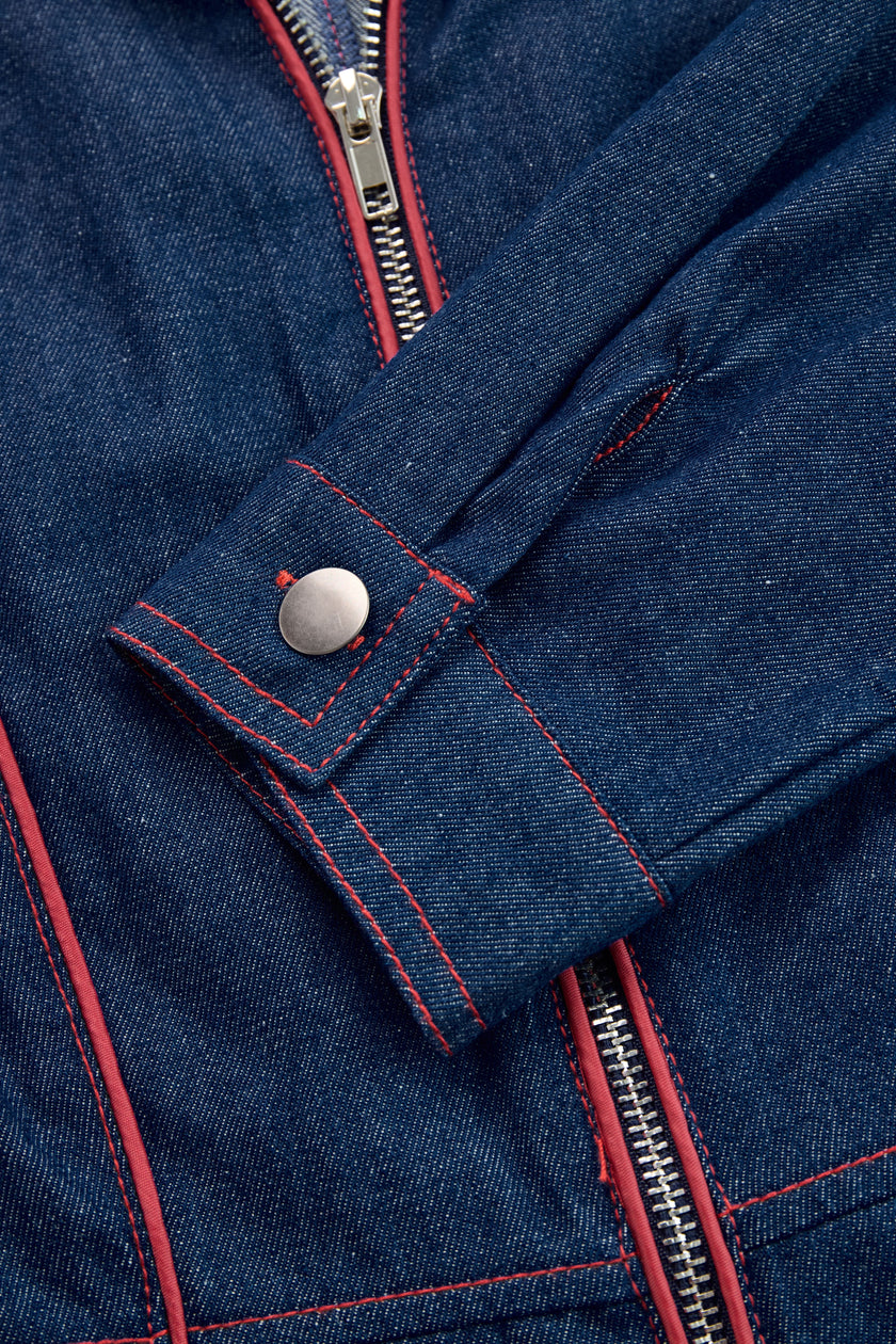Dark blue FJØRNA women's denim jumpsuit with wide-leg pants, topstitched details, long sleeves, and a relaxed fit.