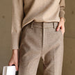 FJØRNA wool blend women's trousers, stylish pants with a tailored fit, shown in a neutral color on a model.