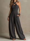 Women's charcoal pinstripe halter neck wide-leg jumpsuit by FJØRNA, featuring a stylish halter top and flowing wide-leg pants.