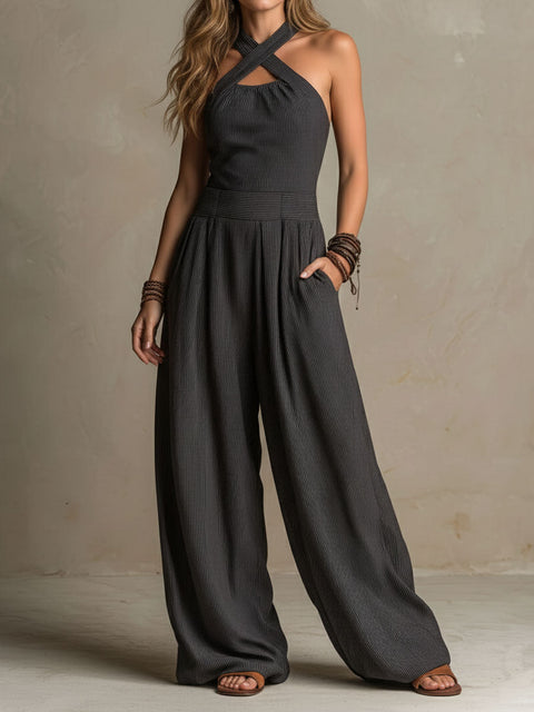 Women's charcoal pinstripe halter neck wide-leg jumpsuit by FJØRNA, featuring a stylish halter top and flowing wide-leg pants.