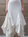 FJØRNA white v-neck midi dress with ruffled hem, elegant and flowing, perfect for casual or semi-formal occasions.