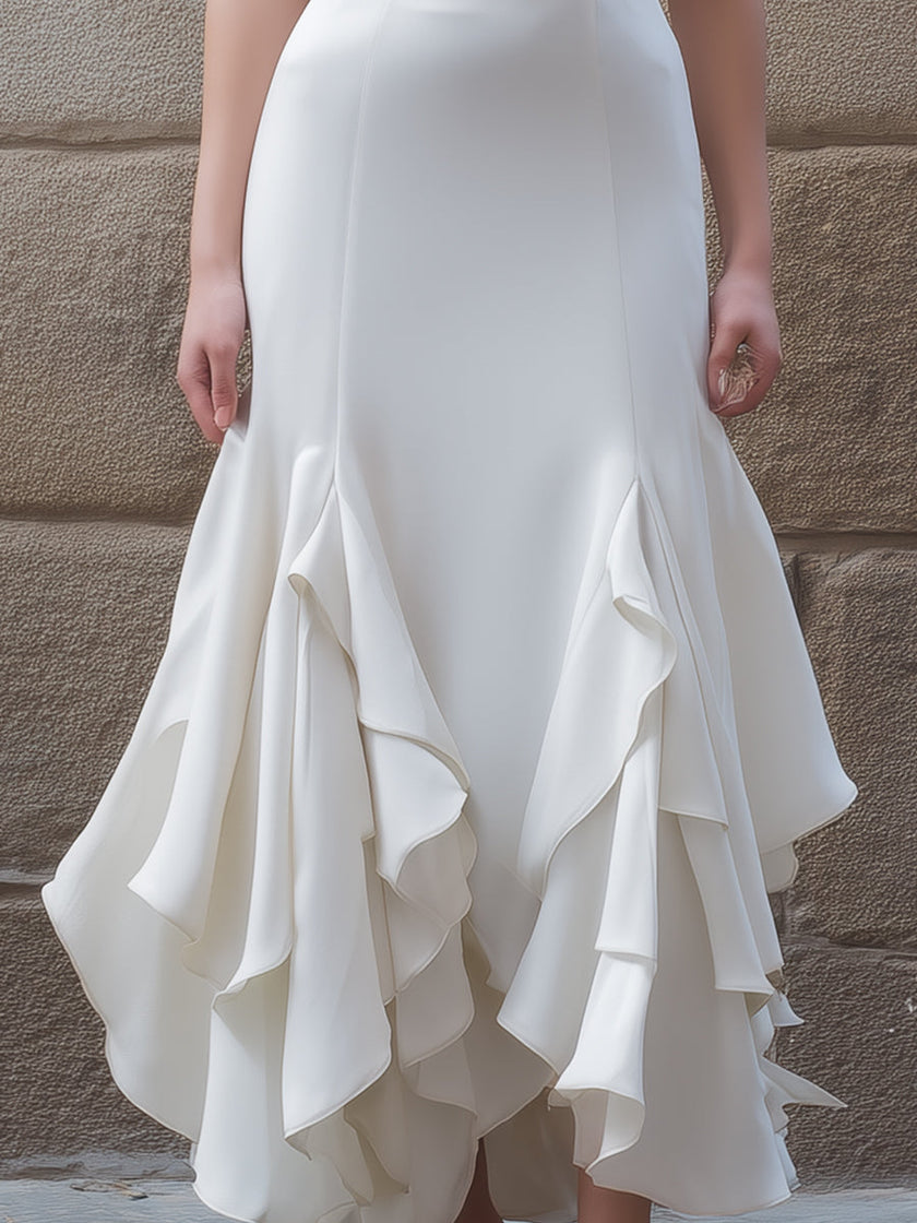 FJØRNA white v-neck midi dress with ruffled hem, elegant and flowing, perfect for casual or semi-formal occasions.