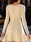 Cream cable knit V-neck flare hem sweater dress by FJØRNA, mini length, with long sleeves and cozy textured fabric.