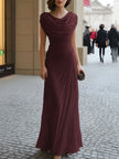 FJØRNA black draped cowl-neck ruched maxi dress displayed on a hanger, showcasing its elegant flowing fabric and sophisticated style.