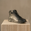Men's black high-top leather Chelsea boots with side zipper from FJØRNA, showcasing sleek design and sturdy sole.